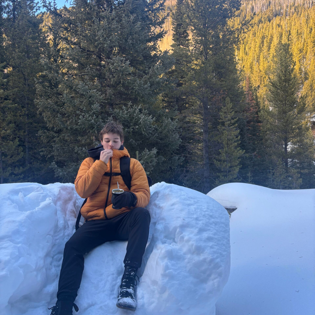 College graduate journaling on a mountain during a gap year, preparing for law school with travel and reflection.
